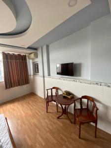 胡志明市Thanh Bình 2 Hotel的客厅配有桌子和两把椅子