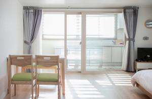 济州市Jeju Aria Pension的一间卧室配有桌子、两把椅子和一张床