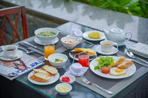 归仁Nam Thu Hotel的餐桌上摆放着早餐食品和饮料