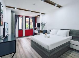 胡志明市AILEN BOUTIQUE HOTEL的卧室配有一张白色大床和电视。