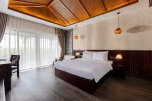 宁平Athena Premier Resort Ninh Bình的卧室配有一张白色大床和一张书桌