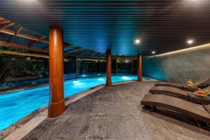 宁平Athena Premier Resort Ninh Bình的一座带长椅和灯光的建筑中的游泳池