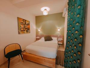 纳杜尔Ramla Valley Vista in Nadur Gozo的一间小卧室,配有一张床和一把椅子