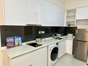 努沙再也Elysia Park Residence Medini Homestay Legoland Gleneagles Johor的厨房配有白色橱柜和洗衣机。