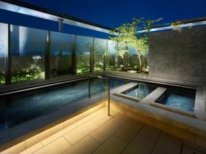福冈Mitsui Garden Hotel Fukuoka Gion的房屋中间的游泳池