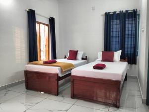 科钦KOVIL home's Guest land的带窗户的客房内设有两张单人床。
