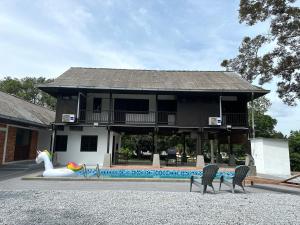 波德申The Wooden Retreat by Elite Stay的一座带游泳池的房子,前面有天鹅