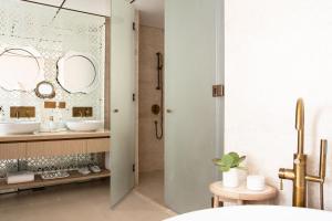 阿布扎比Jumeirah Saadiyat Island Abu Dhabi的浴室配有盥洗盆和带镜子的淋浴
