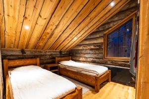列维Kelomattila的小木屋卧室内的两张床,设有窗户