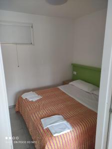 托尔托雷托Villaggio Welcome Riviera d'Abruzzo的一间卧室配有一张床,上面有两条毛巾
