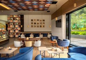 哥印拜陀O by Tamara Coimbatore的餐厅配有蓝色的家具和桌椅