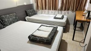 新加坡Haising Hotel的小房间设有两张床和椅子