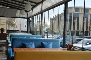 巴库Ariva Hotel and Spa的餐厅设有蓝色的椅子和桌子及窗户。