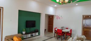 古瓦哈提Mulberry Guesthouse的客厅设有桌子和绿色的墙壁