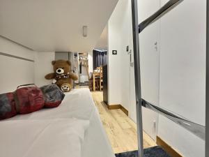 蒂涅Appartement 6 personnes avec Parking Couvert - 1 chambre - 4 lits - Netflix & wifi haut débit的坐在房间里床上的泰迪熊