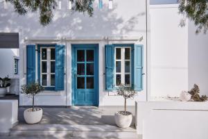 阿斯提帕莱亚镇Chrysalis Boutique - Adults Only的白色的建筑,设有蓝色的门窗