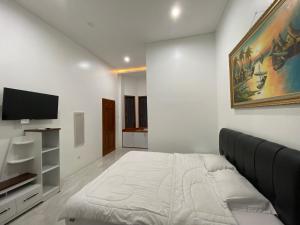 NgagliknDalem Abhirama的一间卧室配有一张床和一台平面电视