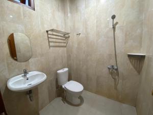 NgagliknDalem Abhirama的浴室配有卫生间、盥洗盆和淋浴。