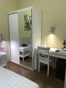 敖德萨弗拉波利酒店的一间带镜子、一张桌子和一张床的卧室