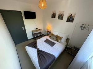 蒙特利马尔Appartement T4 Cosi: TV Netflix Parking的一间卧室配有一张带白色床单的床和电视。