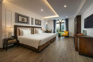 河内Gloud Hotel的酒店客房设有两张床和电视。