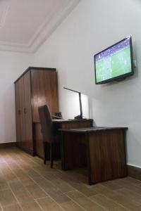科托努Mosaly Residence Caboma的办公室,桌子和墙上的电视