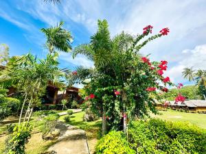 高兰巴恩入住旅馆的种有棕榈树和红色花的花园