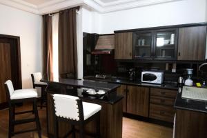 科托努Mosaly Residence Caboma的厨房配有带椅子的柜台和微波炉
