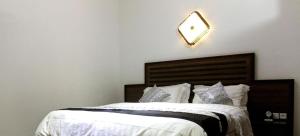 科托努Mosaly Residence Caboma的卧室配有一张挂在墙上的带时钟的床