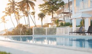 圣塔芭芭拉-山美纳Saman - Paradise With A View - Vista Mare的一座棕榈树游泳池和一座建筑