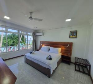 图鲁斯杜巴图塔马尔代夫海浪景观旅馆的一间卧室设有一张大床和一个大窗户