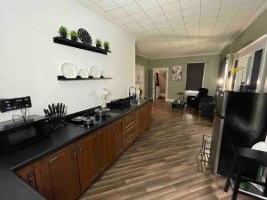 Saint MarysCozy Haven Retreat的厨房铺有木地板,配有黑色台面