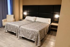 本讷图萨贝内图瑟酒店的一间卧室配有一张带黑白色棉被的床