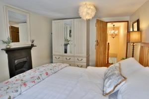 克里克豪厄尔Caboodles Cottage的卧室配有白色的床和壁炉