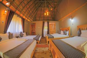 卡塞斯Lake Munyanyange Caves Lodge的一间设有两张床的客房,