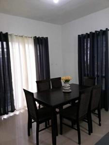 General TriasVacation home in Lancaster new city Cavite Philippines的一间用餐室,配有黑色的桌子和椅子