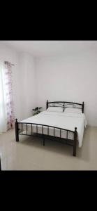 General TriasVacation home in Lancaster new city Cavite Philippines的白色客房的一张床位,床架
