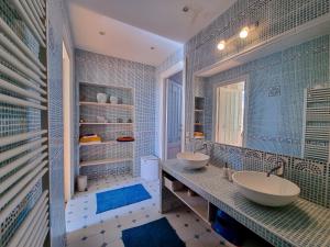 贝沙克和凯洛Chateau Erigoye的浴室设有2个水槽,铺有蓝色瓷砖。