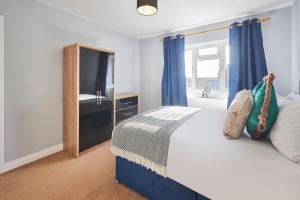 TibshelfHost & Stay - Tibshelf House的一间卧室配有一张带蓝色窗帘的床和一扇窗户