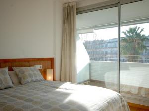 滨海托萨Lets Holidays Tossa de Mar Ancora的一间卧室设有一张床和一个大窗户