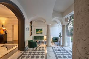 罗马Hotel Principe Torlonia的客厅配有两把椅子和一张沙发