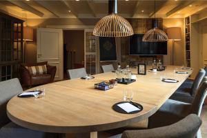 海滨诺德韦克Villa de Duinen - Adults Only的配有椅子的房间里一张大木桌