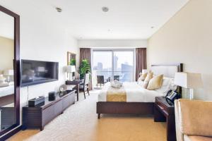 迪拜Address Marina Mall Suites "Full Marina Views & Balcony "的酒店客房,配有床和电视