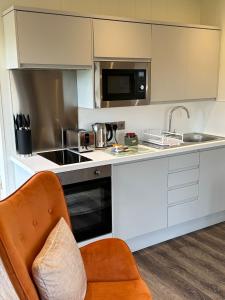 佩尼库克East Kip - Dog Friendly的厨房配有橙色椅子和柜台