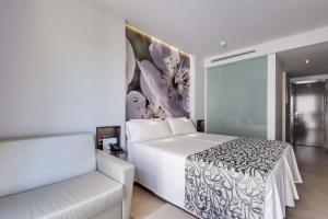 伊利塔斯Barceló Illetas Albatros - Adults Only的卧室配有白色的床和沙发
