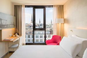 汉堡汉堡巴塞罗酒店的配有一张床、一张书桌和一扇窗户的酒店客房
