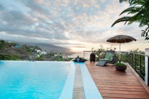 圣乌尔苏拉Villa Horizonte的一座带游泳池和遮阳伞的别墅