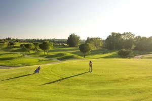 赫雷斯-德拉弗龙特拉Barceló Jerez Montecastillo & Convention Center的站在绿色高尔夫球场上的人