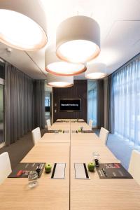 汉堡汉堡巴塞罗酒店的一间会议室,配有长桌子和白色椅子