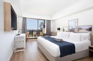 科斯塔特吉塞Barceló Lanzarote Active Resort的酒店客房设有一张大床和一个阳台。